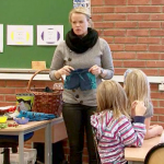 En lærer holder opp en badebukse foran klassen. 