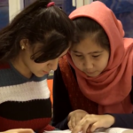 Bilde av to elever som ser på en tekst sammen