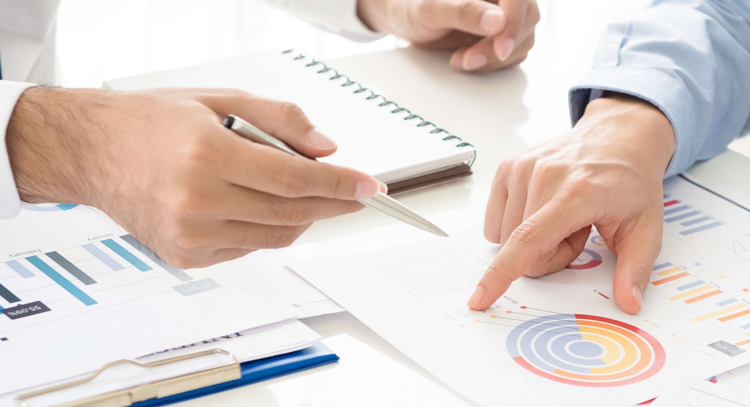 hender peker på diagrammer på et bord