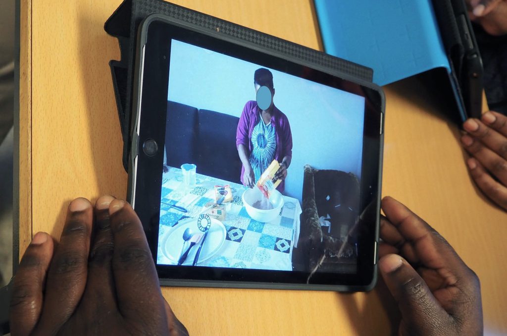 Foto av en IPad. På IPaden er det et foto av en person som baker.