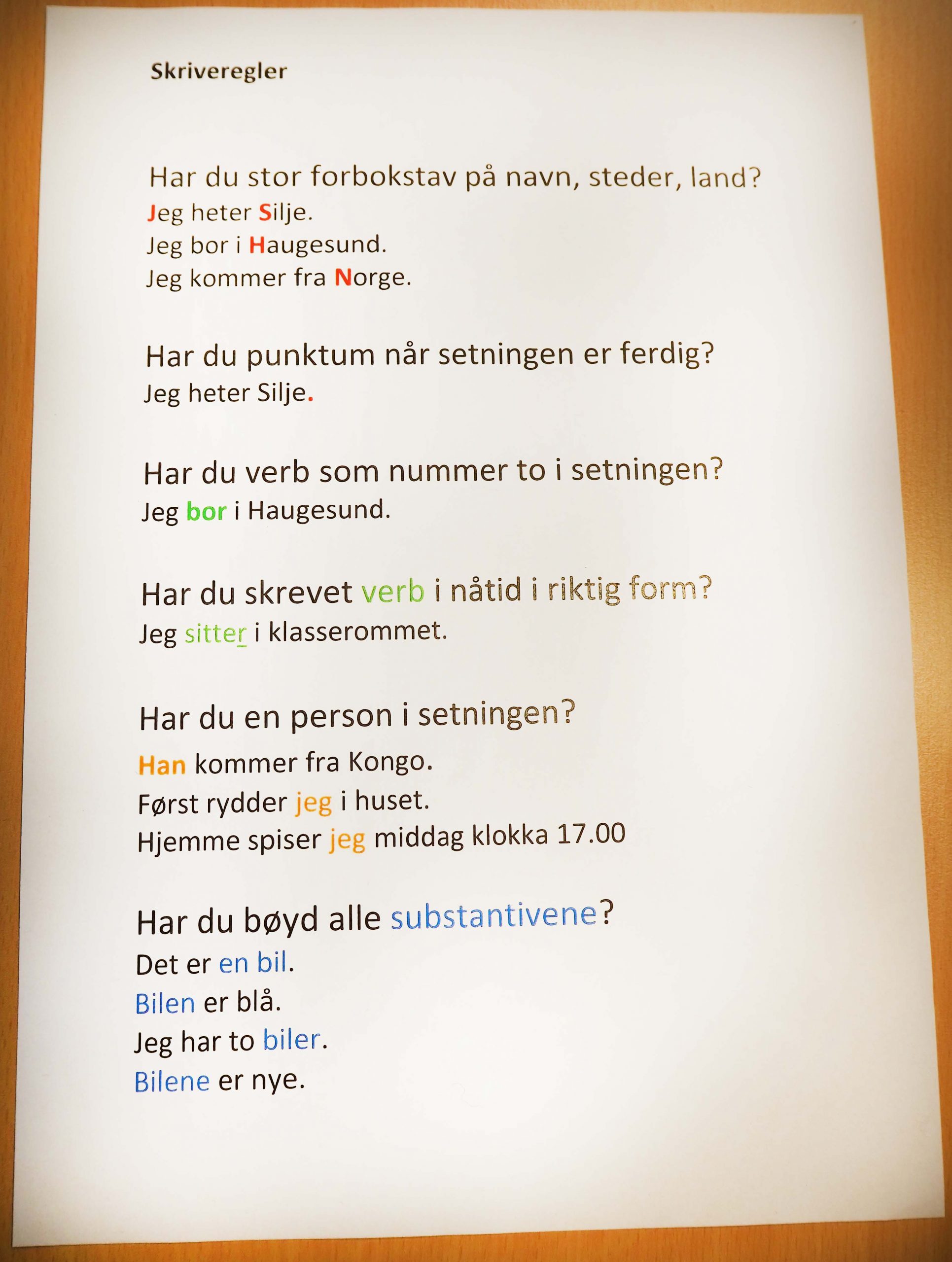 Foto av en et ark med skriveregler. Regel 1: Har du stor bokstav. Eksempel Jeg heter Silje. Jeg og Silje har røde store bokstaver. De andre reglene er punktum når setning er ferdig, verb på plass nummer to, verb i nåtid, person i setningen, bøye substantiv.