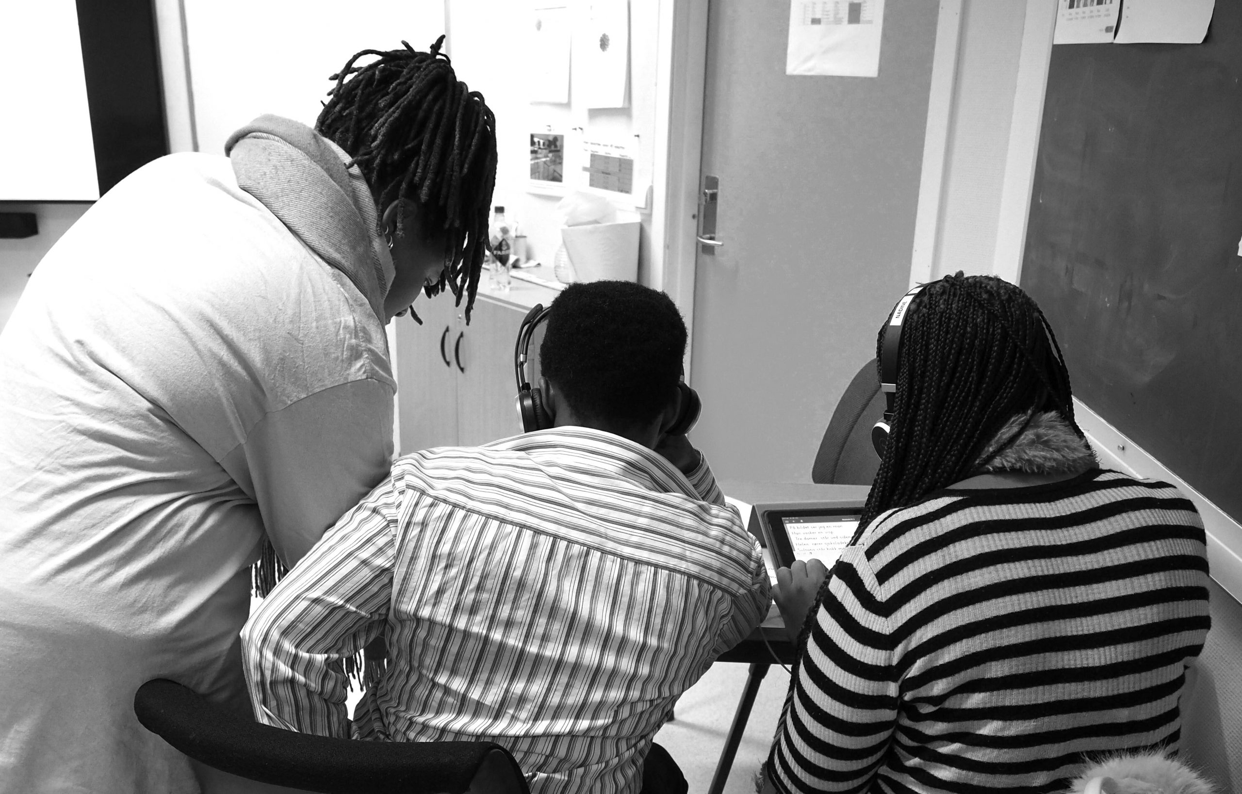 Foto av to deltakere i norskopplæringen og deres flerspråklige assistent