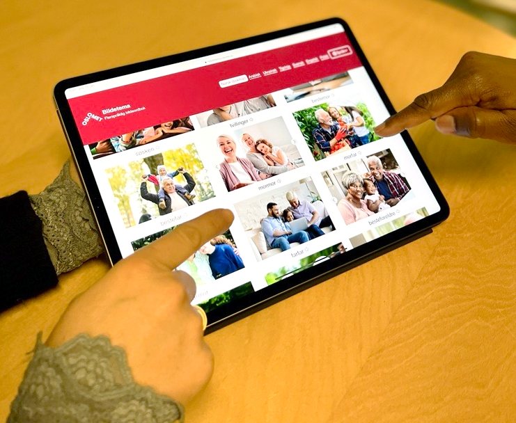 Foto av en skjerm med ordboka Bildetema. To par hender peker på skjermen.