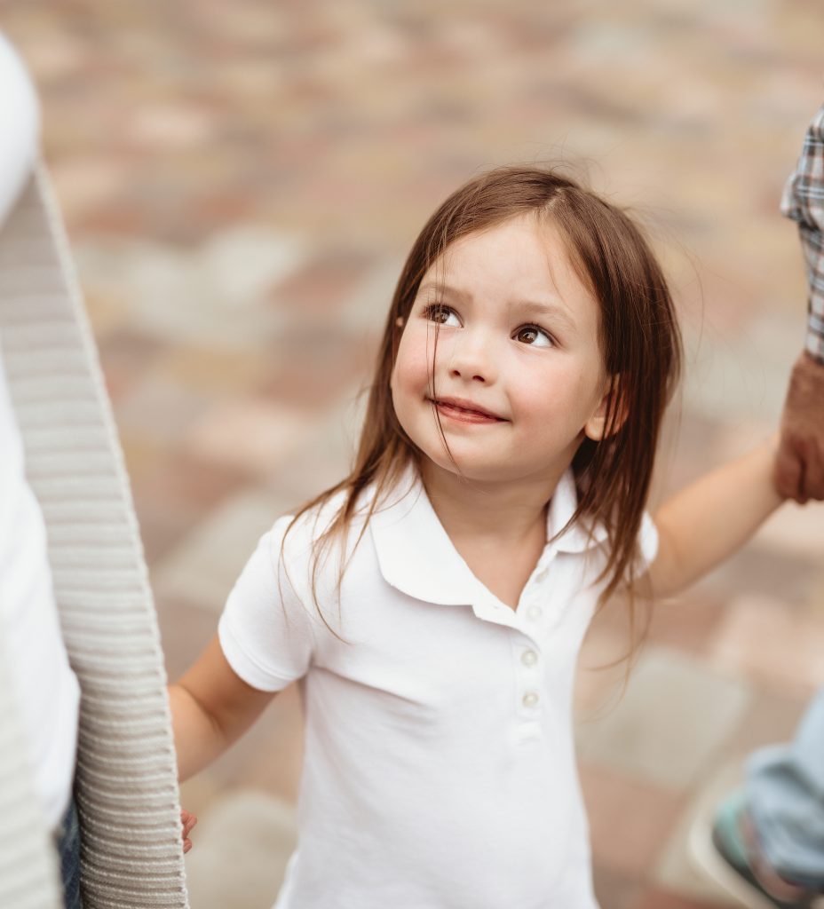 Foto av jente som holder foreldrene sine i hendene