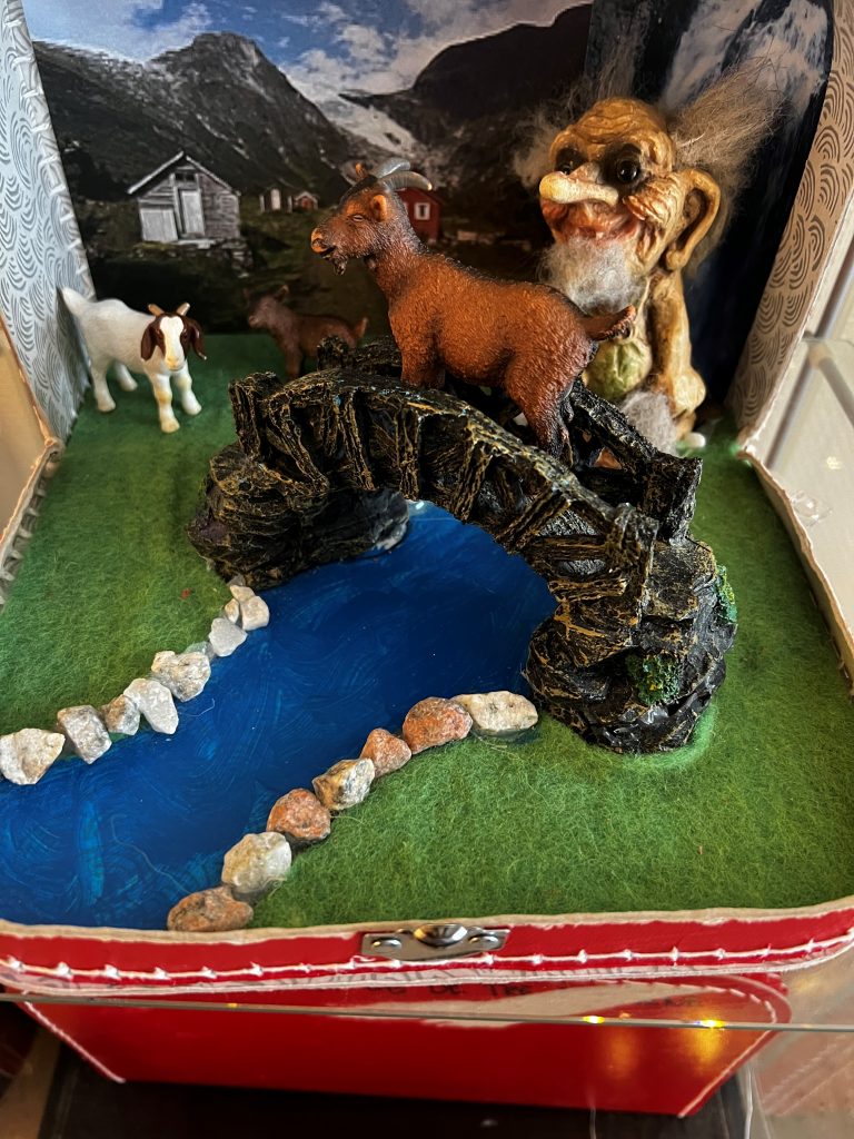 Foto av innholdet i eventyrkoffert med elv, bro og dyr