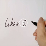 Skjermbilde fra filmen Skriving - miniforelesing. Bildet viser en hånd som skriver med svart tusj på hvitt papir. Ordene "liker å..." står på papiret.