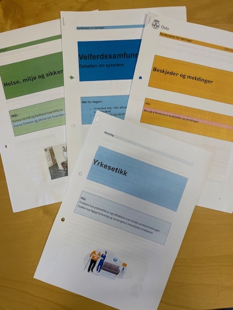 Foto av opplæringshefter som er utarbeidet for ulike temaer. På et hefte står det yrkesetikk, på et annet: beskjeder og meldinger, på et tredje velferdsamfunnet og på et fjerde helse, miljø og sikkerhet.