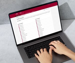 Foto av en laptop med LEXIN-ordbøkene på skjermen og hender som taster på tastaturet