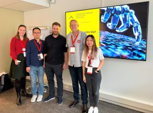 Foto av Eli Rugaard, Kevin Utap, Kjetil Roppestad, Bjørn Teistung og Ye Cai foran en skjerm.