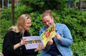 Foto av Elise Finnanger og Lene Østli som ser i en bok.