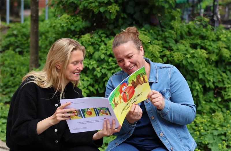 Foto av Elise Finnanger og Lene Østli som ser i en bok.