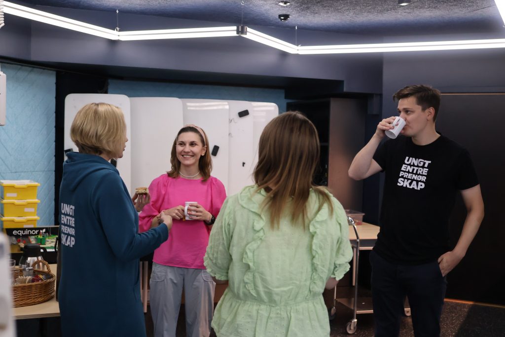 Foto av fire personer som står og snakker sammen.