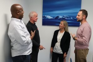 Foto av fire lærere som står og snakker sammen.