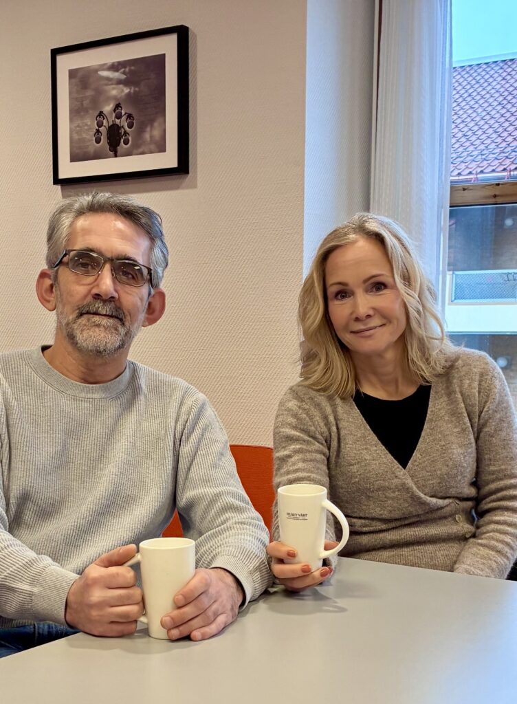 Foto av Ali Albakar og Elin Svalastog. De sitter ved et bord med hver sin kaffekopp.